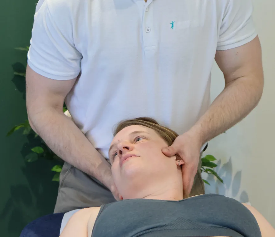 Josh Devine treating a patient's neck and shoulder